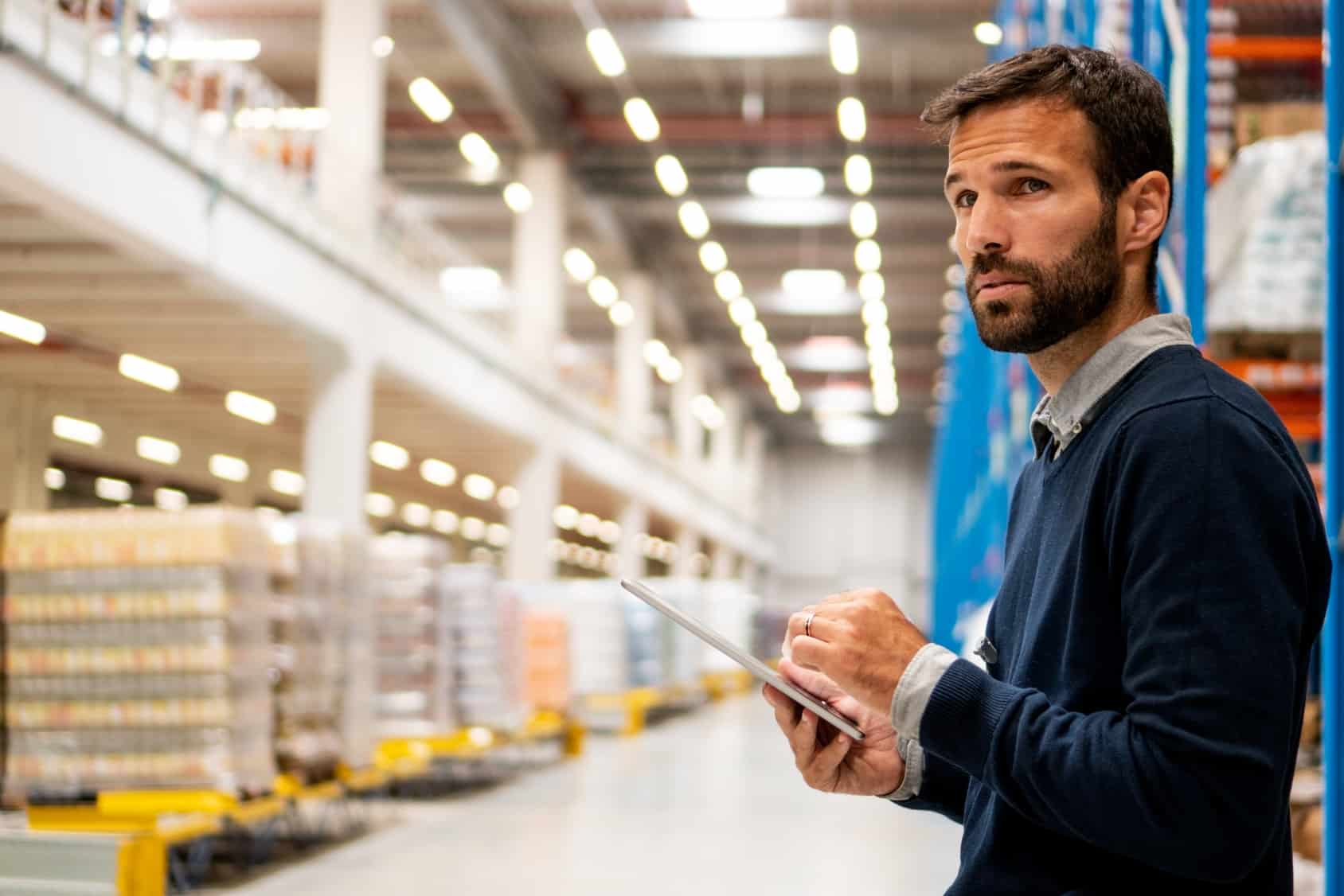 Manager in warehouse holding digital tablet